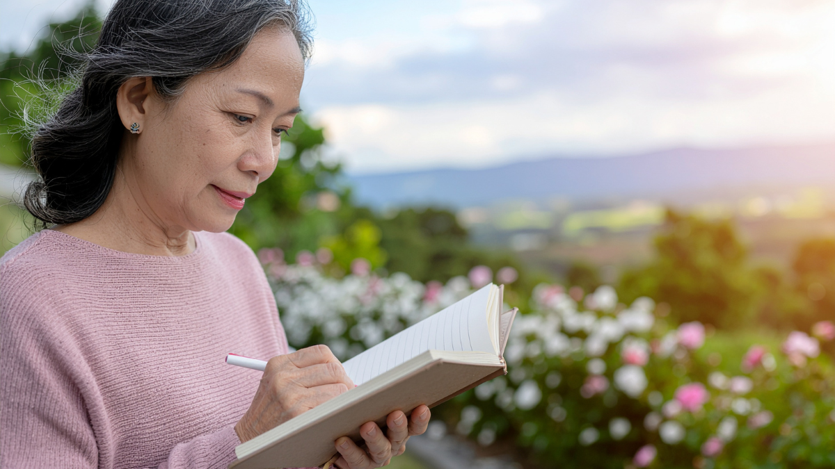 woman writing in notebook while walking outside