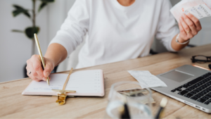 a woman's hand writing notes in planner