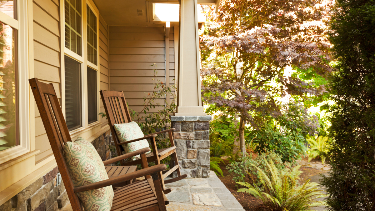 Wooden rocking chairs on a peaceful front porch in soft morning light