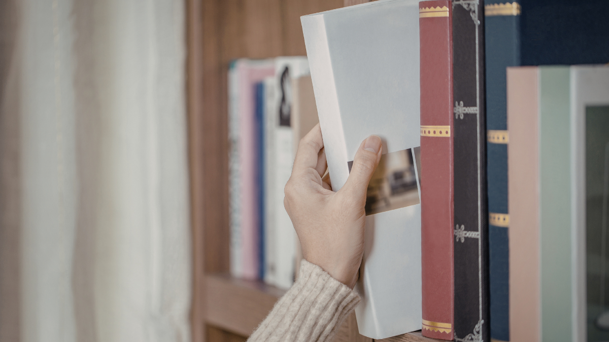 Lit bedside table with a lamp and book as part of a calming self-care routine in real life
