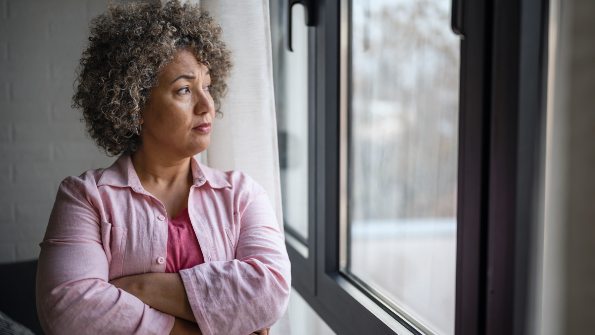 Woman standing by a window in a quiet reflective moment